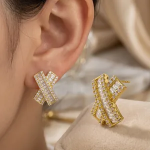 Elegant gold brass X-shaped stud earrings with baguette and round cut cubic zirconia