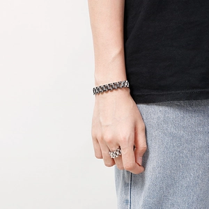 Silver stainless steel watch-link bracelet and ring set worn by a male model