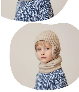 Detail of beige knit winter hat and neck warmer set with snowflake earflaps for kids