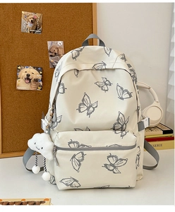 Close-up of butterfly print backpack with cloud charm and front zipper compartment