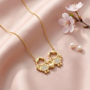 Collier doré avec pendentif garçon fille et cœur orné de strass étincelants