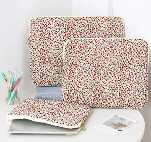 Florale Laptoptasche mit silbernem Tablet innen, zeigt Stauraum und weißen Reißverschluss