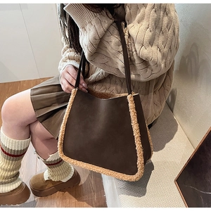 Close-up of deep brown suede tote bag featuring warm beige faux fur trim details
