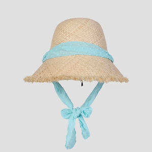 Close-up of raffia sun hat with light blue polka dot chiffon ribbon and frayed brim edges