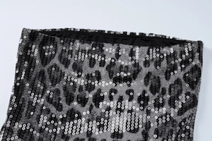 Détail macro de paillettes à motif léopard noir et blanc sur une robe moulante
