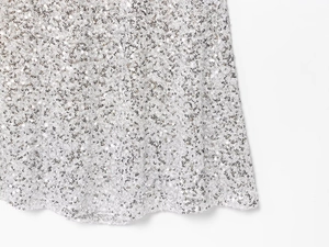 Gros plan de paillettes argentées sur tissu avec texture métallique scintillante
