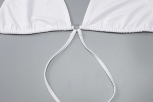 Détail de la robe en maille blanche avec anneau métallique argenté sur tissu élastique