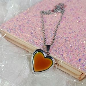 Macro shot of silver heart mood necklace pendant showing color-changing stone and chain