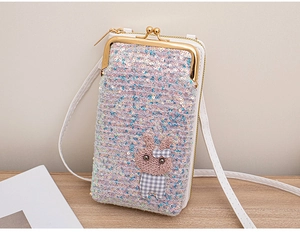 Detailed view of sequin crossbody phone bag with a brown knit rabbit patch and white strap