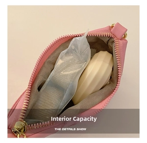 Close-up of pink leather crossbody bag interior showing spacious storage and grey lining