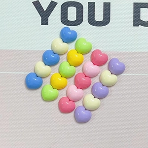 Close-up of heart-shaped macaron resin charms in assorted pastel colors for DIY crafts