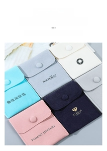 Close-up of velvet jewelry pouches with snap buttons in multiple pastel colors