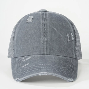 Macro view of distressed grey cotton baseball cap showing ripped details and mesh panels