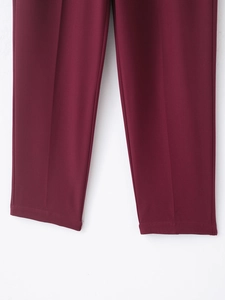 Detailed view of burgundy trouser hems featuring high-quality twill fabric and clean stitching
