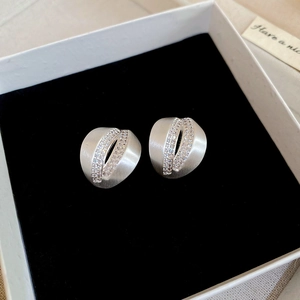 Macro shot of brushed silver C-shape earrings with double rows of zircon inlay