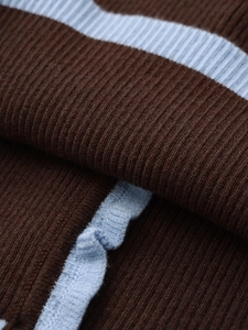 Macro shot of vertical ribbed knit fabric with sky blue ruffles and striped texture details