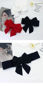 Close-up of wide elastic corset belt featuring a large 3D fabric bow in red, black and white