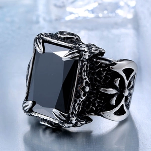 Macro shot of gothic steel ring with black rectangular stone and cross engraving