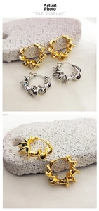 Detailed view of twisted wave hoop earrings in 18K gold and silver polished finish