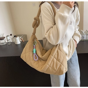 Close-up of khaki quilted shoulder bag with diamond pattern and knotted strap detail