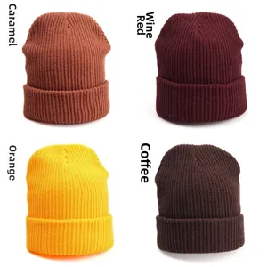 Detail view of four ribbed beanies in caramel, wine red, orange-yellow, and coffee colors