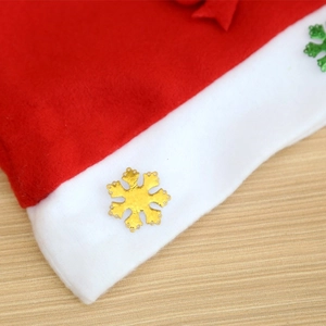 Detail of red Christmas hat with white felt brim and gold and green snowflake charms