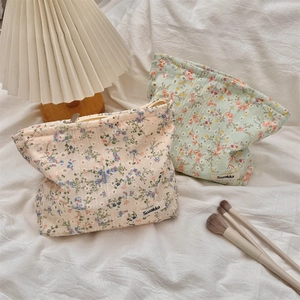 Detailed shot of floral canvas makeup bags with zippers and elegant Sozakka woven label