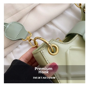 Detail of light green bag with quilted texture and high-quality gold metal swivel hook