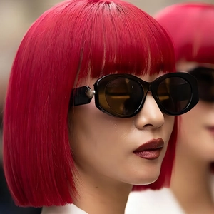 Chic 2025 women's black oval sunglasses styled with a vibrant red bob haircut
