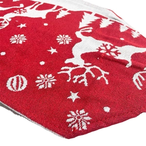 Red and white knitted Christmas table runner with festive reindeer and snowflake patterns