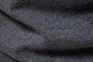 Macro shot of dark grey knit fabric showing detailed texture and soft sweater material