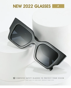 Detail of square black oversized sunglasses on a minimalist white display stand