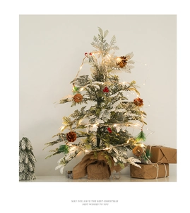 Tabletop Christmas tree with artificial snow, pine cones, red berries and LED lights