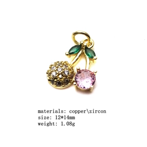 Detailed close-up of a pink zircon cherry pendant with copper and marquise leaf accents