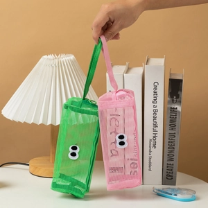 Detail of cute mesh pencil pouches in green and pink with cartoon googly eyes handles
