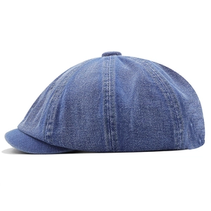 Macro shot of blue washed denim newsboy cap showing texture and panel stitching detail