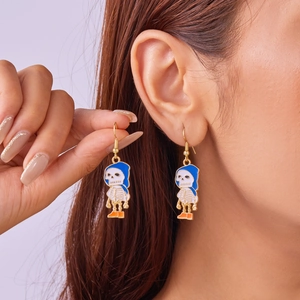 Detailed macro view of a cartoon skeleton earring with blue hat and orange boots