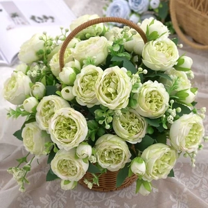 Detailed view of white artificial roses with green cores in a brown wicker flower basket