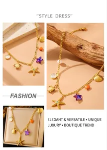 Detail view of gold ocean charms with starfish and turtle pendants on stainless steel chain