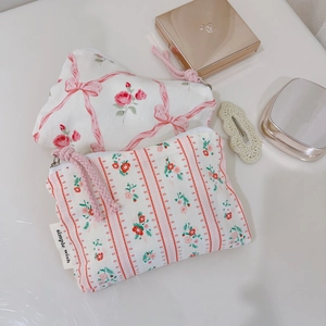 Detailed flat lay of pink floral and strawberry patterned cotton fabric storage pouches