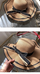 Detail of wide brim straw sun hat with elegant black ribbon and large side bow