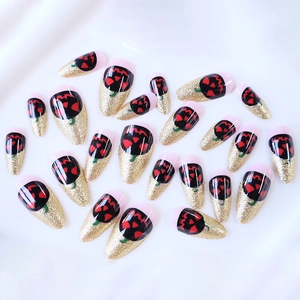 Halloween almond press-on nails featuring glitter gold gradients and black pumpkin designs