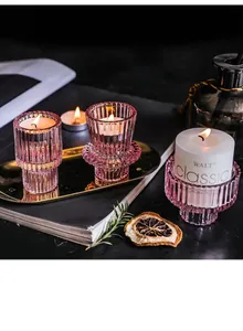 Close-up of pink ribbed glass candle holders with warm candlelight for home decor