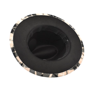 Detail view of the flat brim fedora showing the two-tone plaid edge and black lining fabric