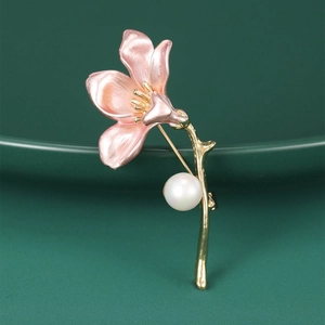 Detailed macro shot of a pink enamel flower brooch with gold stem and a white pearl accent