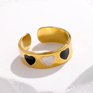 Detail of 18K gold-plated stainless steel ring with black enamel and white shell hearts