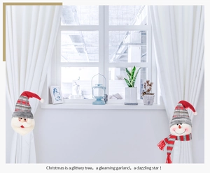 Detail of fabric Santa and Snowman curtain tiebacks in a festive home window setting