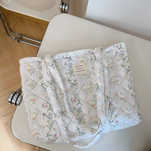 Detailed close-up of French floral quilted shoulder bag featuring tulip print on textile