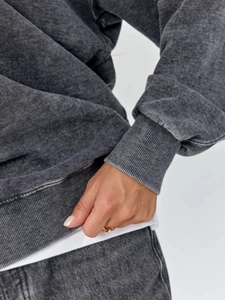 Detail of washed charcoal cotton sweatshirt showing ribbed cuffs and vintage texture