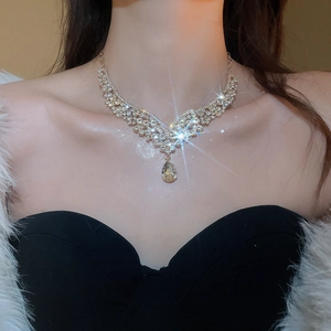 Close-up of sparkling rhinestone necklace with a pear-shaped crystal pendant on a model